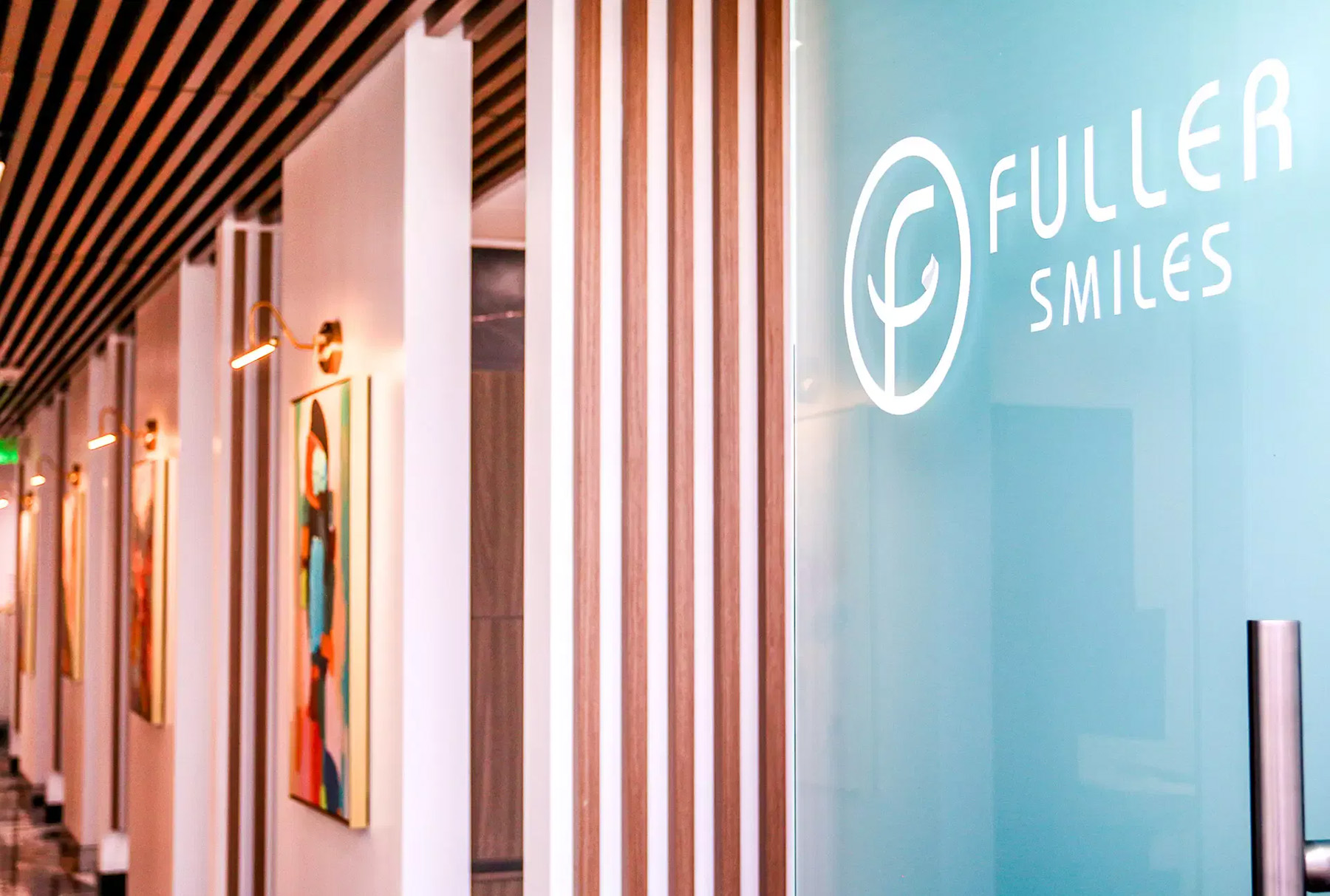 The image shows an interior space with a sign that reads FULLER SMILES on a glass partition, suggesting that this might be the entrance to a dental clinic or practice named Fuller Smiles.